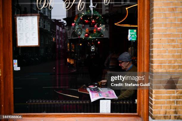 Man reads the newspaper inside a shop on Jordaan District on December 10, 2022 in Amsterdam, Netherlands. Jordaan is a district of the...