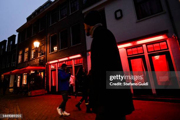 People walks near of red Light inside the Red Light District on December 10, 2022 in Amsterdam, Netherlands.De Wallen, Amsterdam's red-light...