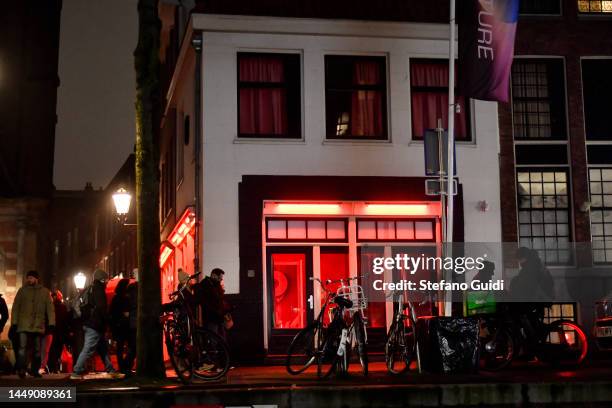 People walks near of red Light inside the Red Light District on December 10, 2022 in Amsterdam, Netherlands.De Wallen, Amsterdam's red-light...