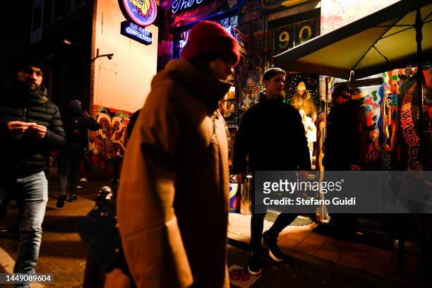 People walks near a Coffeeshop on Red Light District on December 10, 2022 in Amsterdam, Netherlands. De Wallen, Amsterdam's red-light district, is...