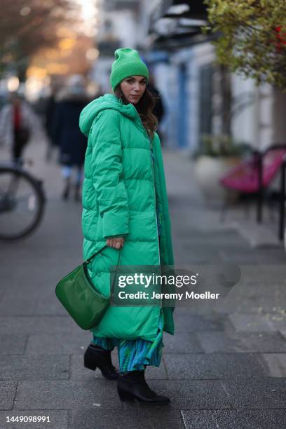 Anna Wolfers seen wearing a green patterned long dress, a matching green beanie, a green bag and black boots on December 09, 2022 in Hamburg, Germany.