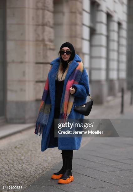 Sonia Lyson is seen wearing Prada triangle black leather bag, Bottega Veneta black and orange leather boots, Max Mara blue teddy oversized coat, Zara...