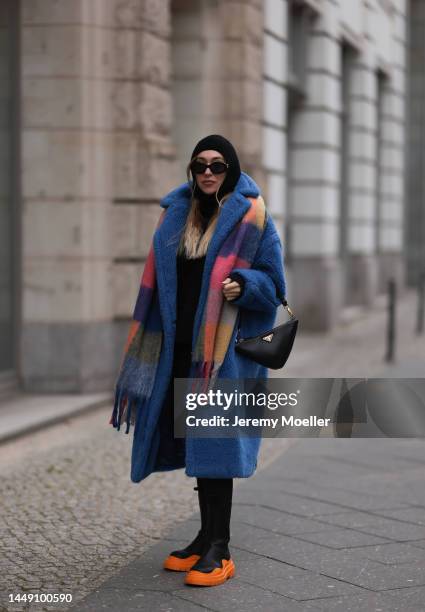 Sonia Lyson is seen wearing Prada triangle black leather bag, Bottega Veneta black and orange leather boots, Max Mara blue teddy oversized coat, Zara...