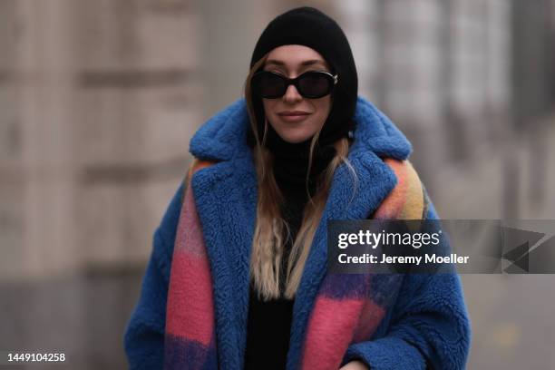 Sonia Lyson is seen wearing Max Mara blue teddy oversized coat, Zara colorful checked knit scarf, Celine round black sunglasses and & Other Stories...
