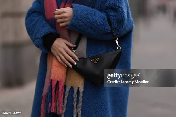 Sonia Lyson is seen wearing Prada triangle black leather bag, Max Mara blue teddy oversized coat and Zara colorful checked knit scarf on December 13,...