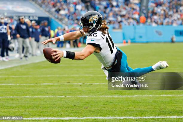 Trevor Lawrence of the Jacksonville Jaguars dives into the end zone for a touchdown during a game against the Tennessee Titans and runs for a...