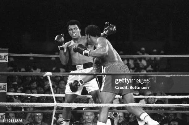 George Foreman grazes Ali with a left in their title fight.