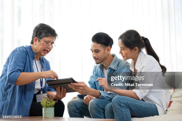 protect and care for your family with long term life insurance planning. an asian female insurance broker agent is showing a budget and making the discussion to life insurance planning to a customer. - long term investment stockfoto's en -beelden