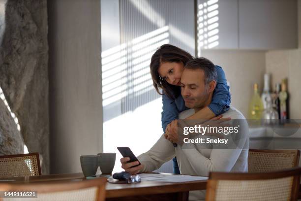 couple paying their bills with phone - forced marriage stockfoto's en -beelden