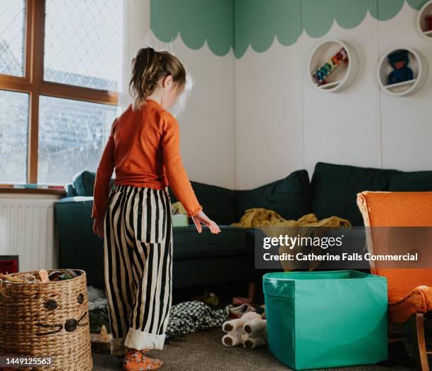 a little girl in a untidy playroom - child picking up toys stock pictures, royalty-free photos & images