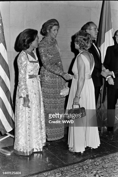 Lise-Marie Sauvagnargues, Nancy Kissinger, guest, and Jean Sauvagnargues attend a party at the National Gallery of Art in Washington, D.C., on...