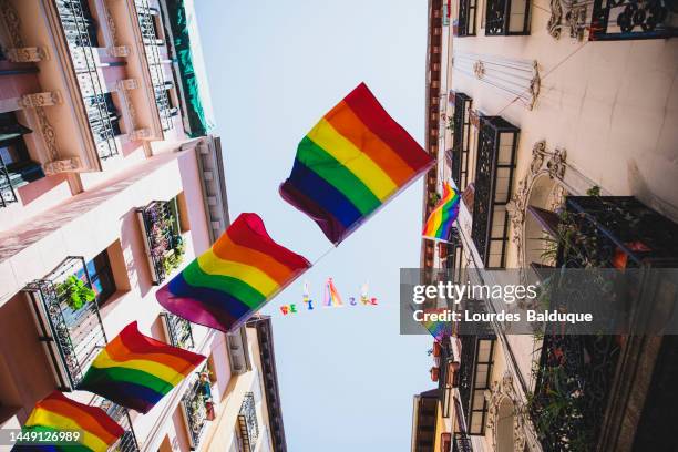 rainbow flags hung from balconies in madrid - lgbtqi pride event stock pictures, royalty-free photos & images