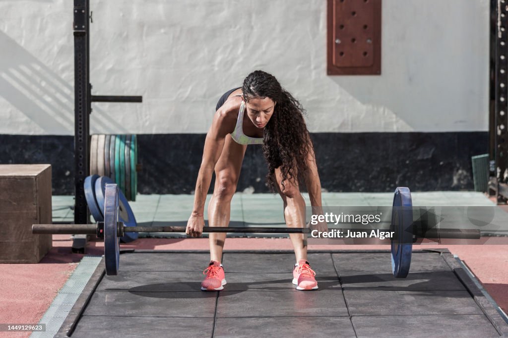 Hispanic weightlifter exercising with barbell