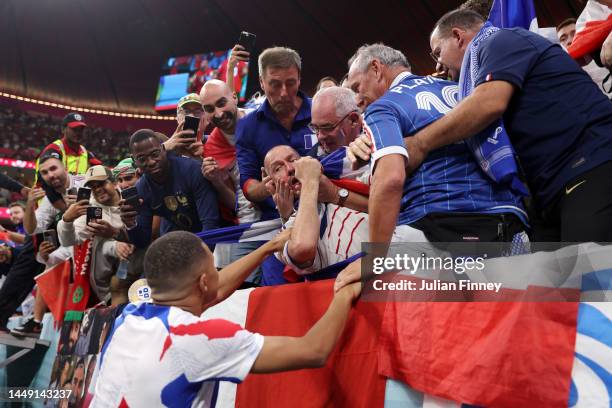 Kylian Mbappe of France apologizes to a fan who was hit by a stray ball during the FIFA World Cup Qatar 2022 semi final match between France and...