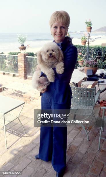 American actress, singer, and businesswoman Debbie Reynolds poses for a portrait with her dog, Los Angeles, California, circa 1970.