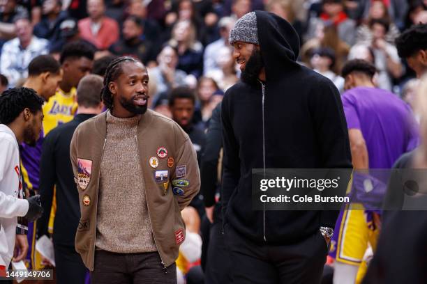 LeBron James and Patrick Beverley of the Los Angeles Lakers stand on the court in street clothes while on the injured list during the first half of...