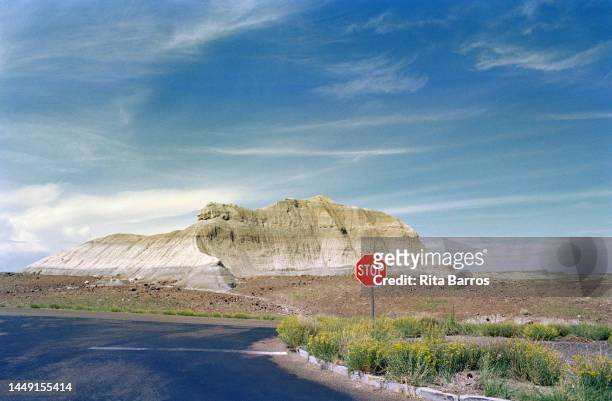 View along a road, past a stop sign, of a mesa, Arizona, August 2006.