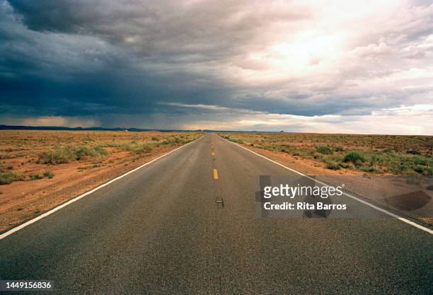 View of storm clouds above an empty road in the desert, Arizona, August 2006.