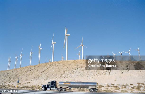 View, over a moving tanker truck on an interstate highway, of turbines in a wind farm, Palm Springs, California, August 2006.