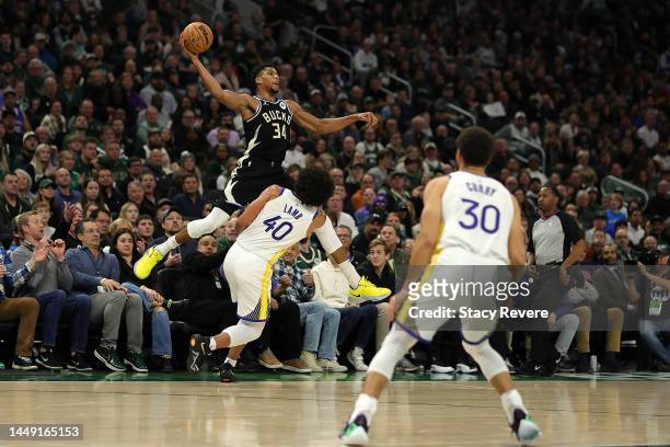 Giannis Antetokounmpo of the Milwaukee Bucks looks to pass over Anthony Lamb of the Golden State Warriors during a game at Fiserv Forum on December...