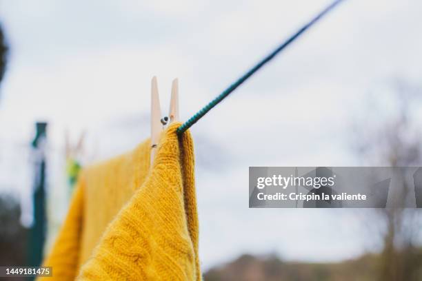 orange blanket drying on the clothesline at garden - ropa tendida fotografías e imágenes de stock