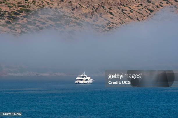 Plaka, Crete, Greece, Sea mist cloud about to engulf a leisure cruiser off the resort of Plaka in Crete a Greek island, .