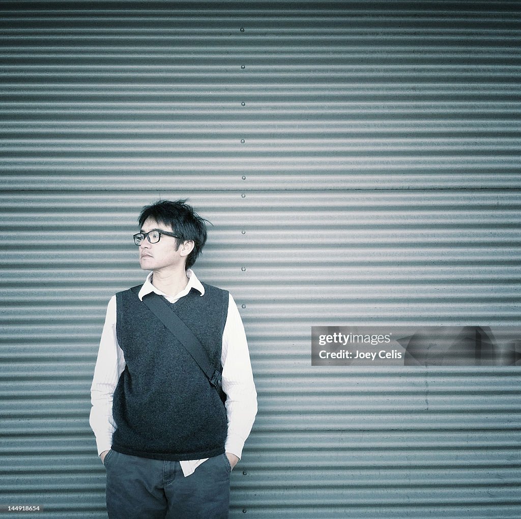 Man standing in front of urban metal wall