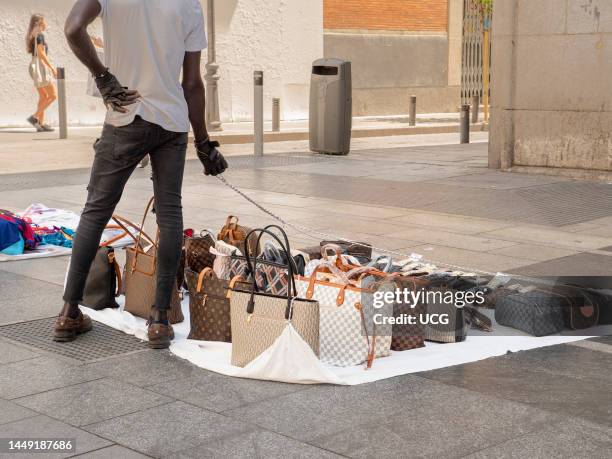 Street vendor selling counterfeit handbags, Madrid, Spain.