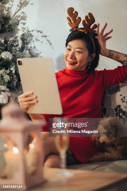 tattooed chinese woman celebrating new year's alone at home - chinese year of the dog stock pictures, royalty-free photos & images
