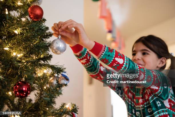 middle eastern young girl decorating the christmas tree. - arabic ornament stock pictures, royalty-free photos & images