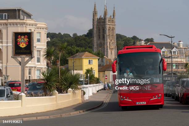 Teignmouth, Devon, England, UK, Red touring coach driving through the seaside town of Teignmouth in south Devon, England, UK.