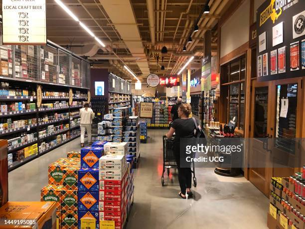 Woman shopping at Wegmans in the local craft beer aisle, Boston, Massachusetts.
