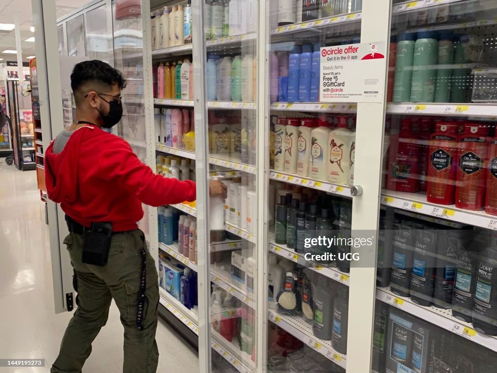 Target employee stocking personal hygiene items in new locked security shelving, Target, Queens, New York