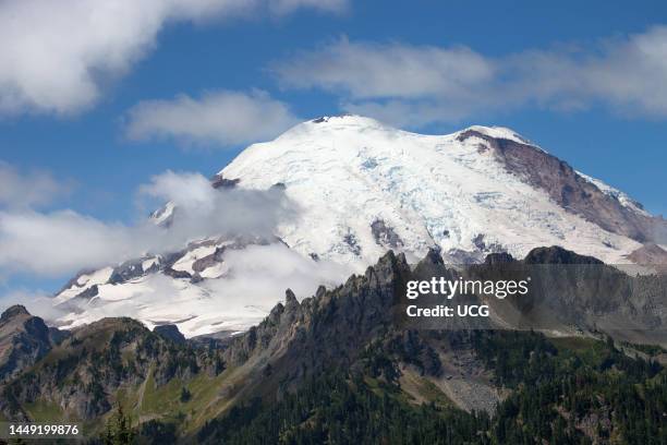 Mt. Rainier, a stratovolcano --covered by ice of the Emmons Glacier. Mt. Rainier National Park, Washington. Cowlitz Chimneys in foreground.