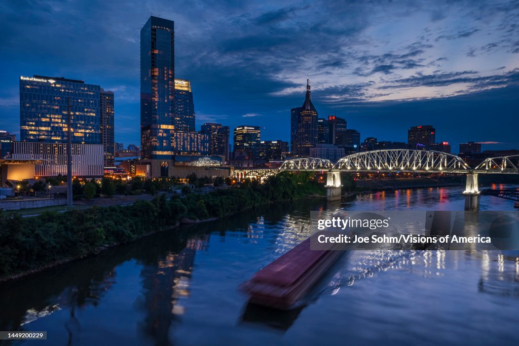 Barge travels up Cumberland River at dusk in Nashville, Tennessee
