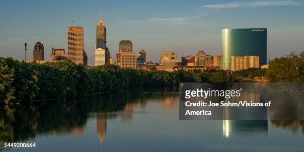 Skyline view at sunset into dusk of Indianapolis buildings on White River reflect in water, Indiana.