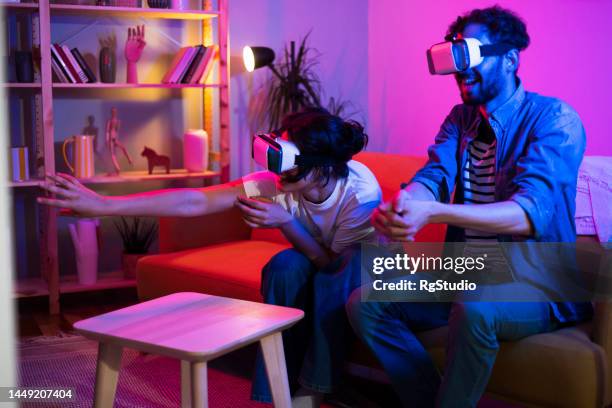 portrait of a young couple using vr headsets and having fun - 360 degree view stock pictures, royalty-free photos & images
