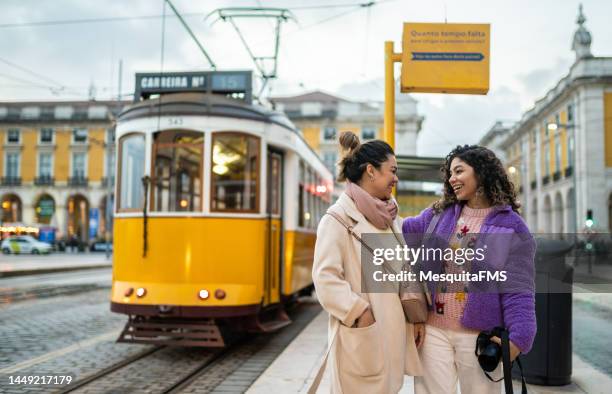people waiting for the tram in lisbon - bushalte stockfoto's en -beelden