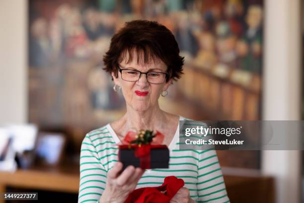 donna anziana infelice per un regalo che ha appena ricevuto - sad birthday foto e immagini stock