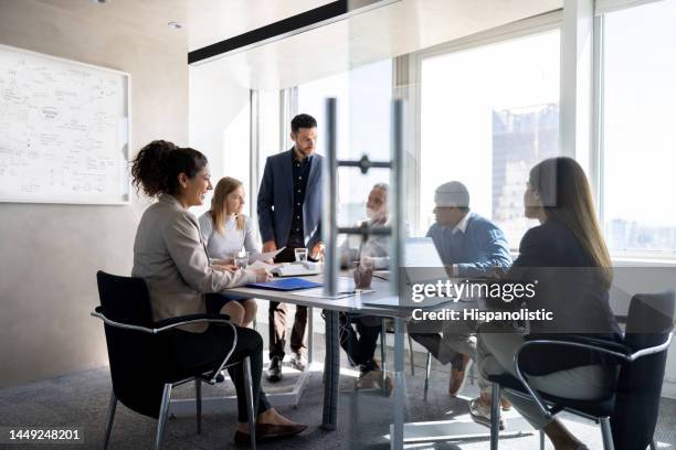 business man talking to his team in a meeting at the office - directievergadering stockfoto's en -beelden