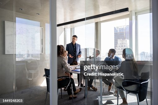 Successful business man talking to a group of people in a meeting a the office Successful business man talking to a group of people in a meeting a the office