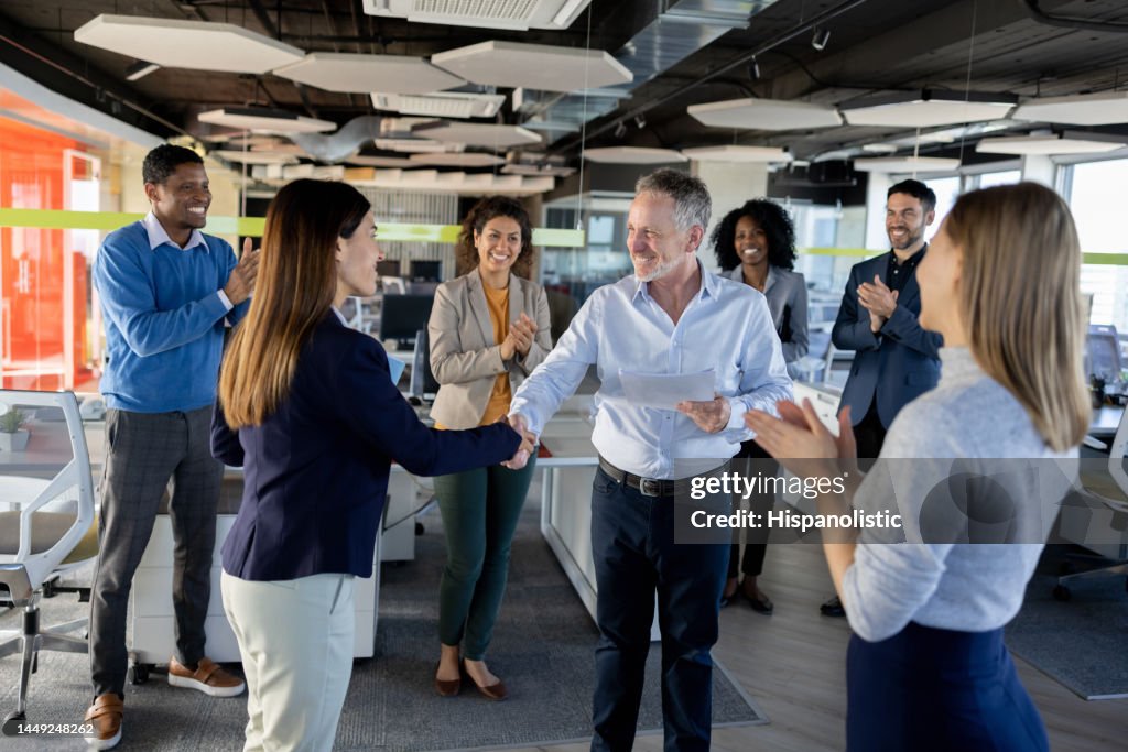 Business woman getting a promotion at work and handshaking her boss