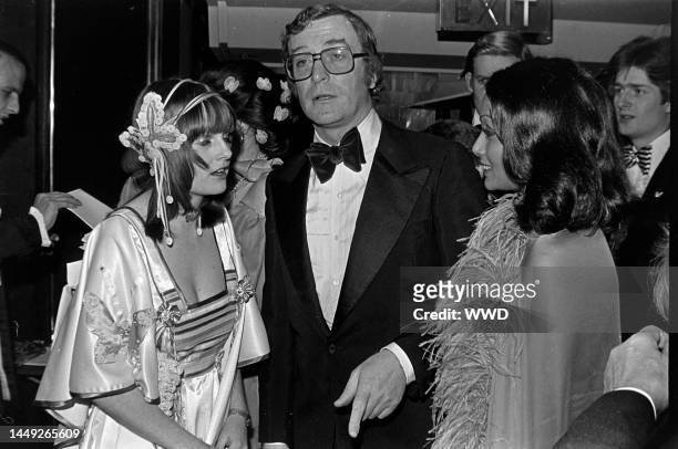 Lady Jane Wellesley, Michael Caine, and Shakira Caine attend a gala at the Intercontinental Hotel in London, England, on March 4, 1976.