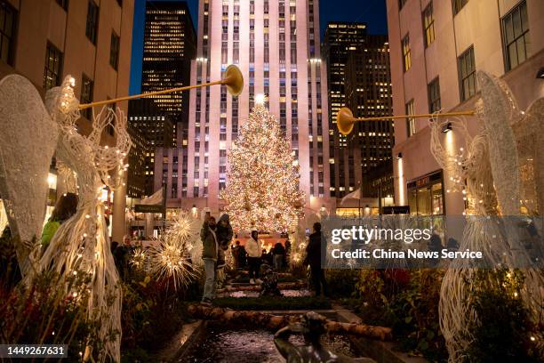 Woman poses for a photo in front of a Christmas tree at Rockefeller Center on December 14, 2022 in New York City.