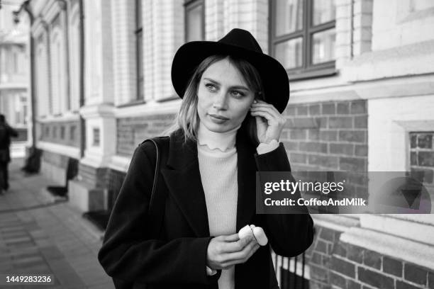 beautiful woman enjoying autumn. black and white photo - close up of beautiful young blonde woman with black hat stock pictures, royalty-free photos & images