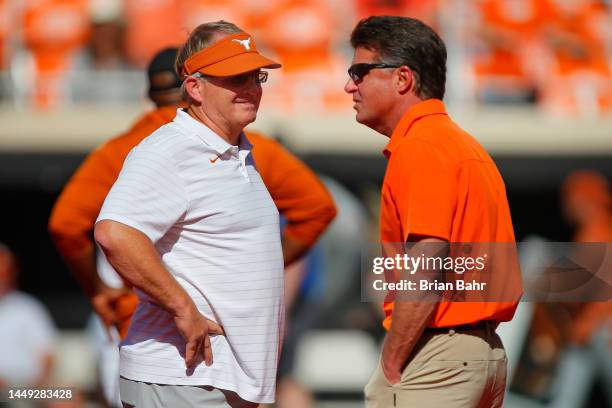 Special assistant to the head coach Gary Patterson of the Texas Longhorns talks with head coach Mike Gundy of the Oklahoma State Cowboys before their...