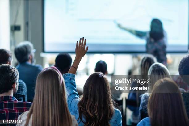 vista posterior de la mujer creativa haciendo una pregunta sobre el evento de educación en la oficina. - pregunta y respuesta fotografías e imágenes de stock