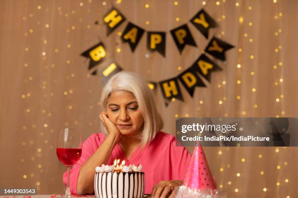 old lady lonely celebrating her birthday at home - sad birthday foto e immagini stock