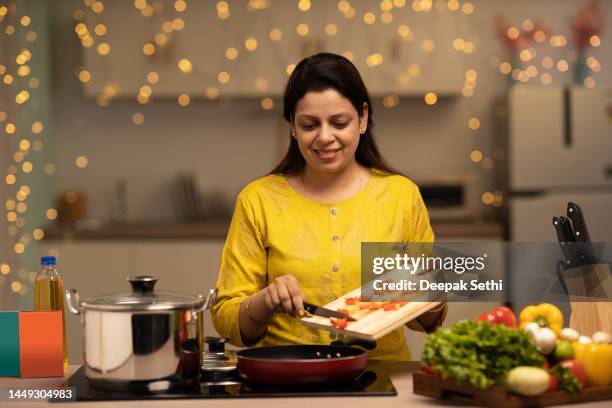 portrait of indian woman enjoying while cooking meal in the kitchen. stock photo - woman make up stock pictures, royalty-free photos & images