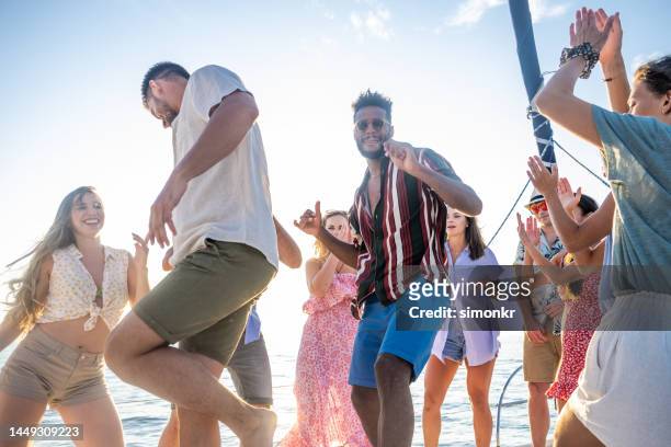 friends dancing on sail boat - pink shorts imagens e fotografias de stock